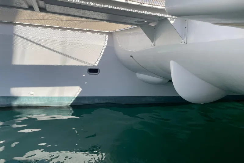 Slide: The Image of 2021 Outremer 51 catamaran hull and netting over calm water. - 8