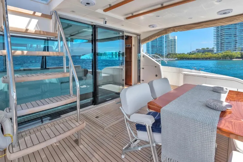 Slide: The Image of Luxurious 2013 Fairline Squadron 66 yacht deck with dining area and scenic waterfront view. - 15