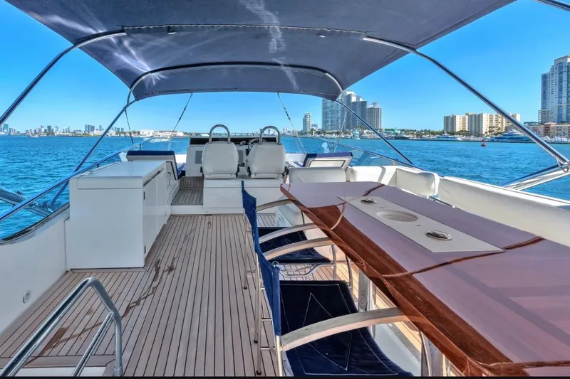 Slide: The Image of Luxurious 2013 Fairline Squadron 66 yacht deck with seating, overlooking city skyline and ocean. - 19