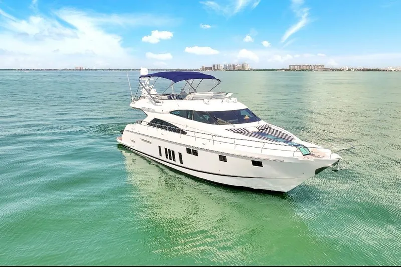 Slide: The Image of Luxury 2013 Fairline Squadron 66 yacht cruising on calm waters under a clear blue sky. - 7