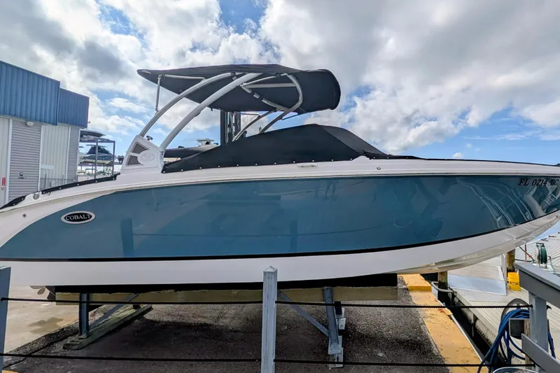 Slide: The Image of 2021 Cobalt R7 boat with blue hull and black canopy on a dock. - 1