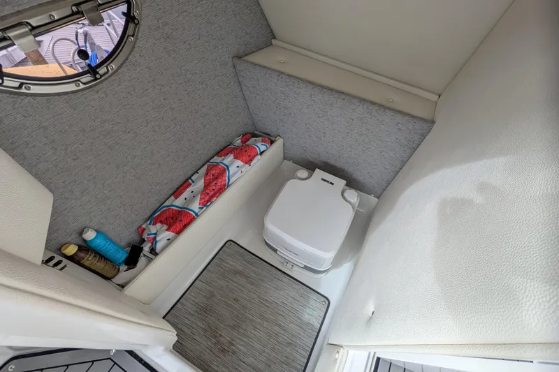 Slide: The Image of 2021 Cobalt R7 boat interior with compact toilet and storage area. - 10