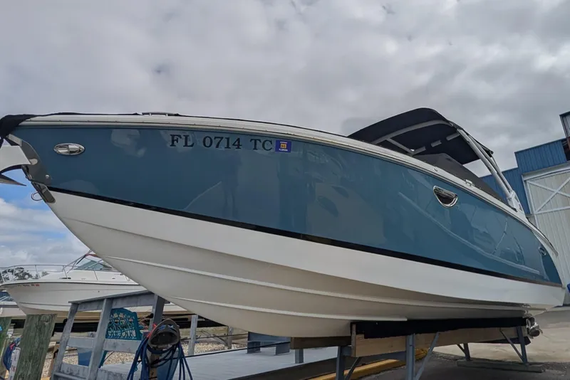 Slide: The Image of 2021 Cobalt R7 boat on trailer, blue and white, overcast sky background. - 2
