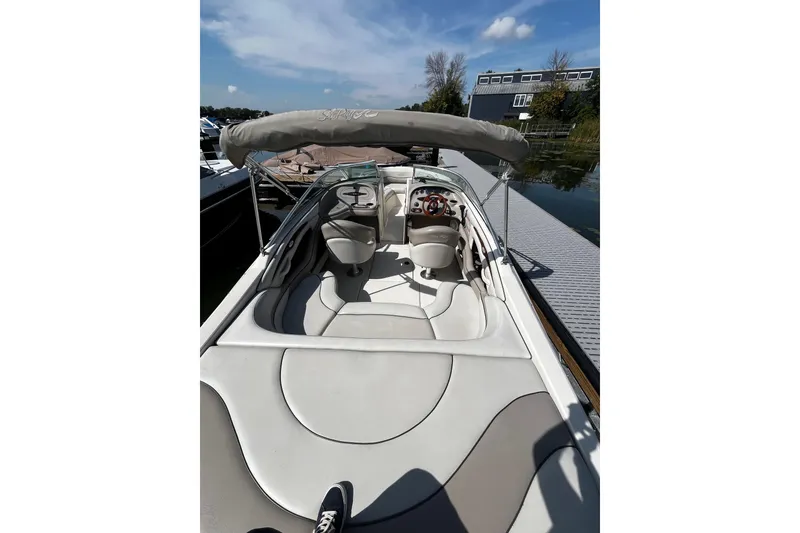 Slide: The Image of 2003 Sea Ray 240 Bow Rider boat with canopy, docked on a sunny day. - 5