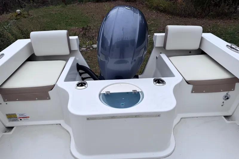 Slide: The Image of 2018 Parker 2120 Sport Cabin boat interior with seating and engine view. - 4
