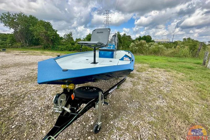 The Image of 2026 SeaArk C1074 Shadow 18TCC boat in blue on a trailer, parked outdoors. - 0