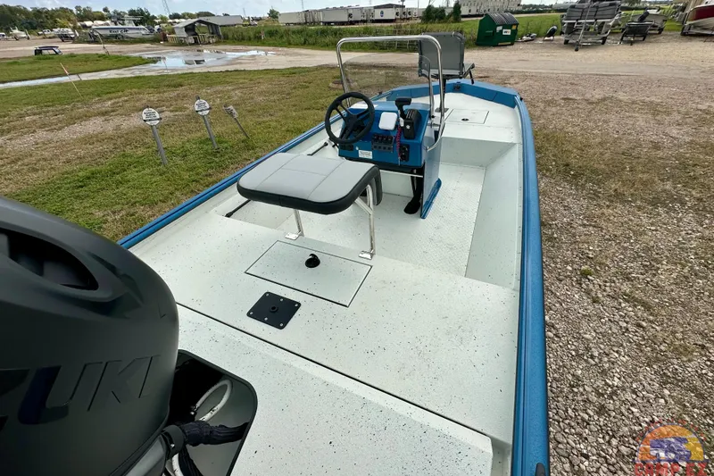 Slide: The Image of 2026 SeaArk C1074 Shadow 18TCC boat with steering console and seating, parked outdoors. - 13