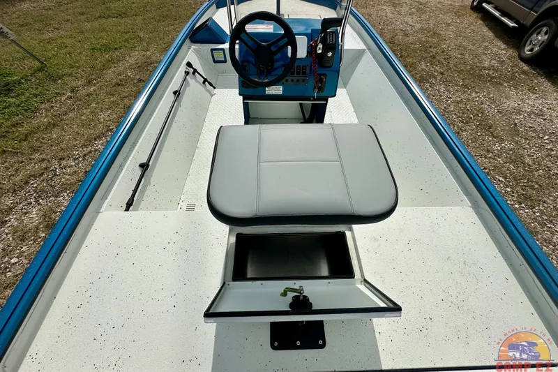 Slide: The Image of 2026 SeaArk C1074 Shadow 18TCC boat interior with steering console and storage compartment. - 16