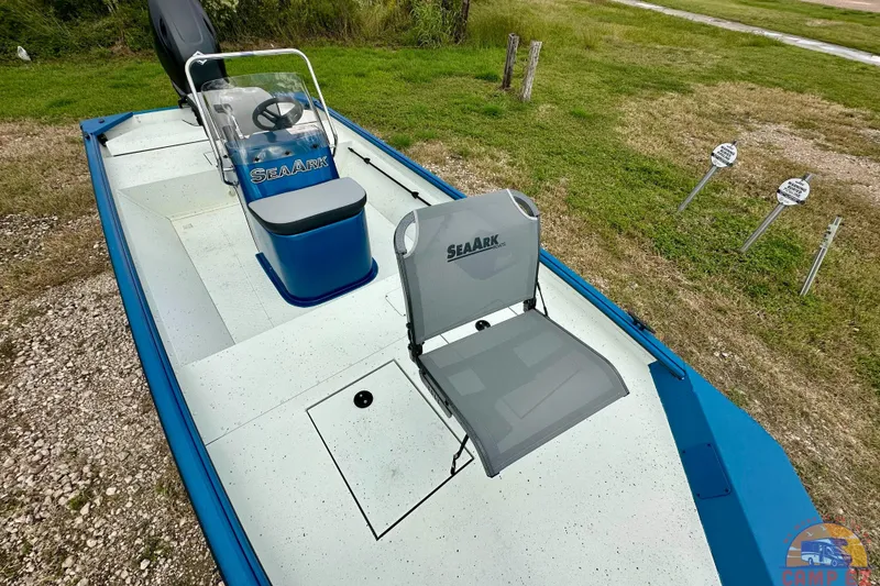 Slide: The Image of 2026 SeaArk C1074 Shadow 18TCC boat with seating, parked on grass. - 21