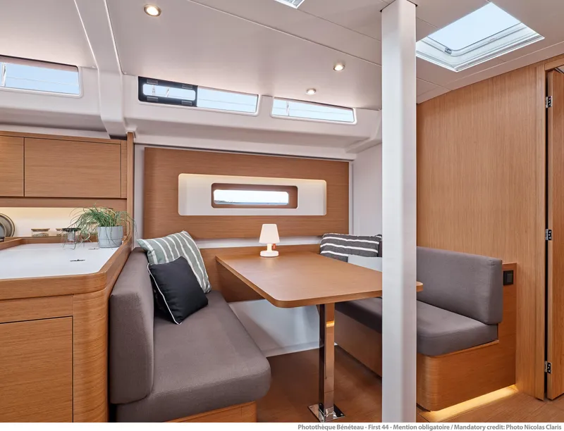 Slide: The Image of Interior of 2025 Beneteau First 44 yacht, featuring modern dining area with wood finish. - 7