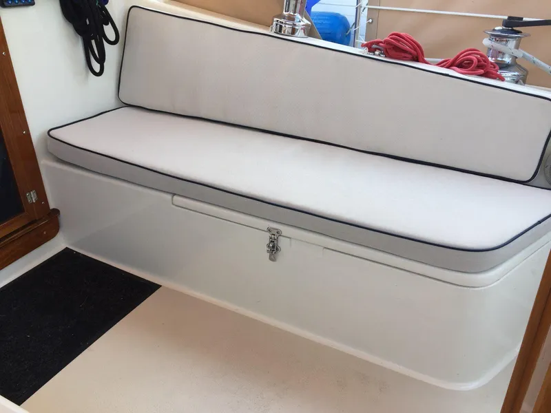 Slide: The Image of 1979 Tartan 37C sailboat interior with cushioned seating and storage compartment. - 14