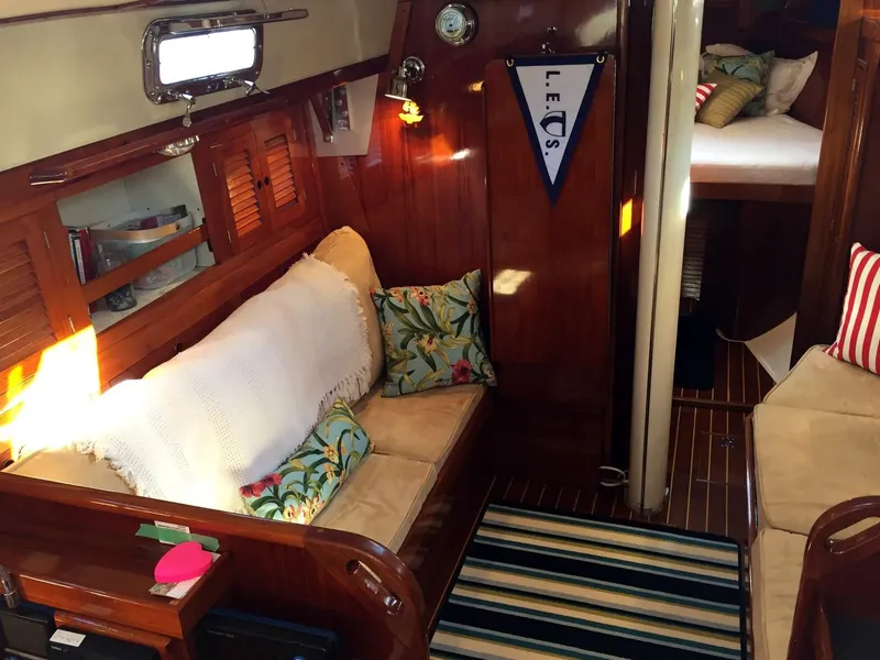 Slide: The Image of 1979 Tartan 37C yacht interior with cozy seating, cushions, and nautical decor. - 17