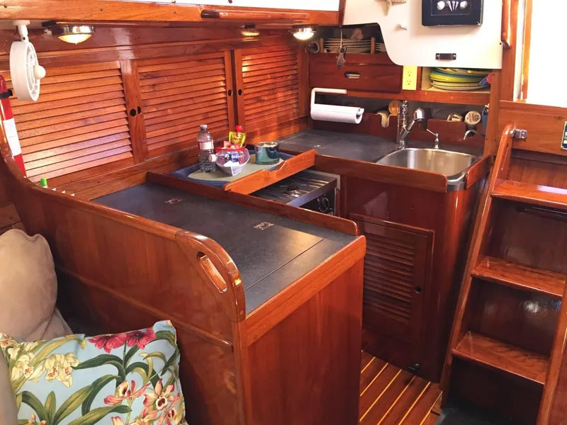 Slide: The Image of 1979 Tartan 37C yacht interior with wooden cabinetry and compact kitchen area. - 24