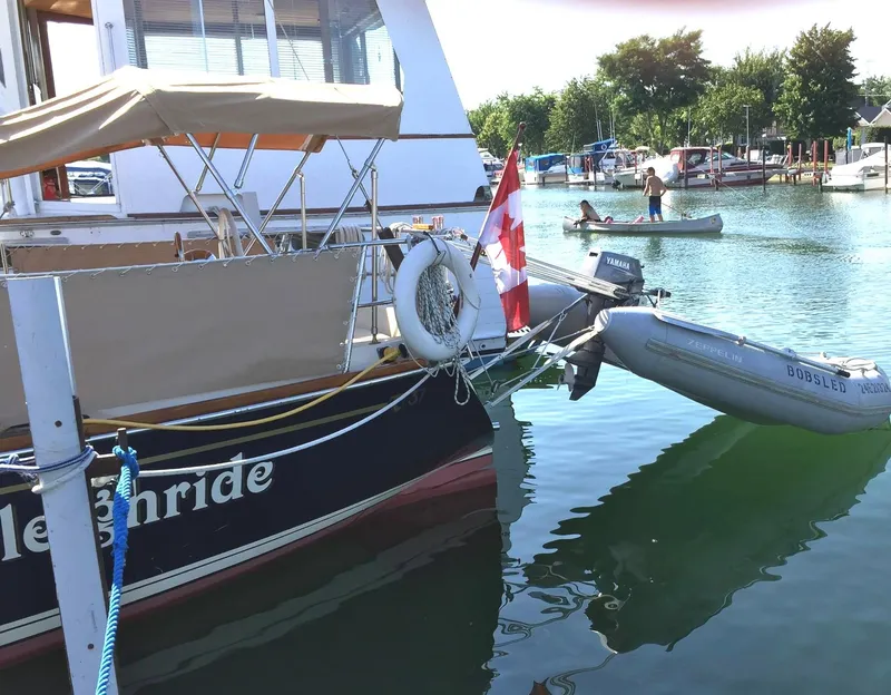 Slide: The Image of 1979 Tartan 37C sailboat docked with Canadian flag and dinghy in sunny marina. - 6