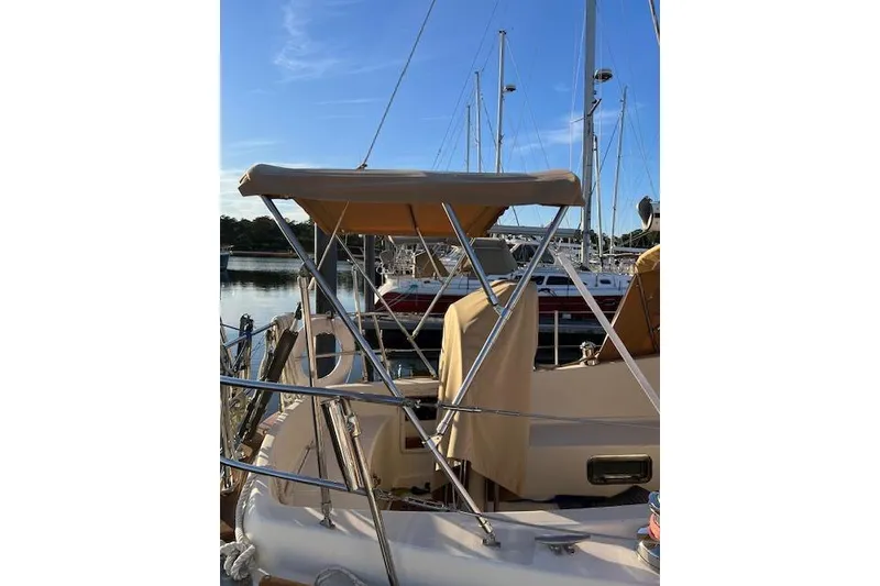 Slide: The Image of 1979 Tartan 37C sailboat docked, featuring a beige canopy and stainless steel frame. - 8