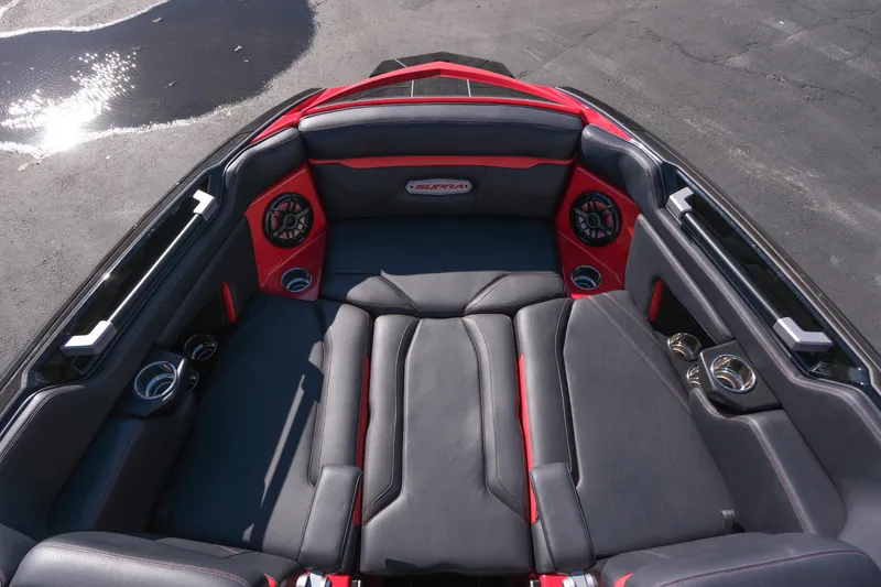 Slide: The Image of 2022 Supra SL boat interior with black and red seating, premium speakers, and cup holders. - 28