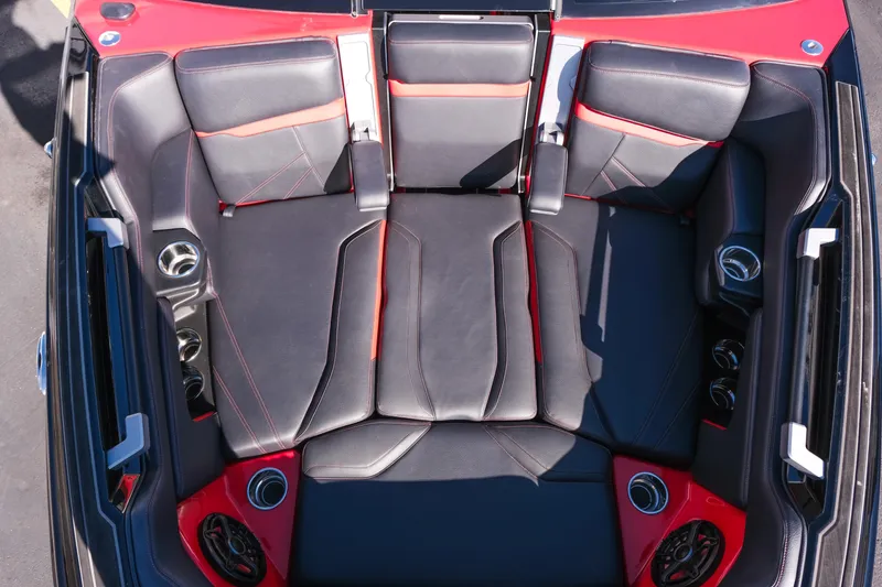 Slide: The Image of 2022 Supra SL boat interior with black and red seating, cup holders, and speakers. - 32
