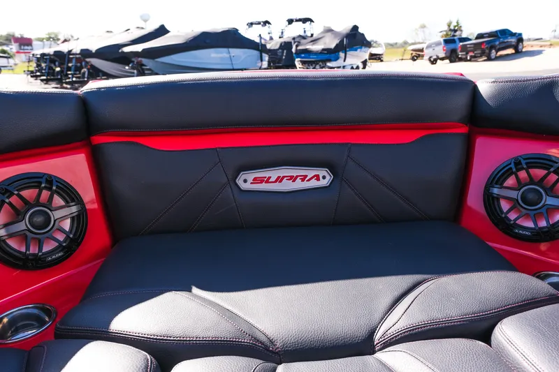 Slide: The Image of 2022 Supra SL boat interior with black and red seating, speakers, and logo. - 34