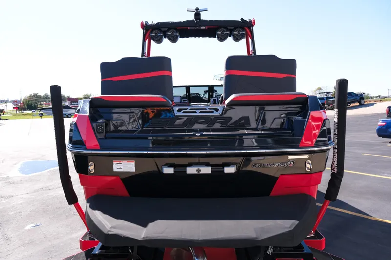 Slide: The Image of 2022 Supra SL boat rear view with red and black design, featuring Swell Surf system. - 7