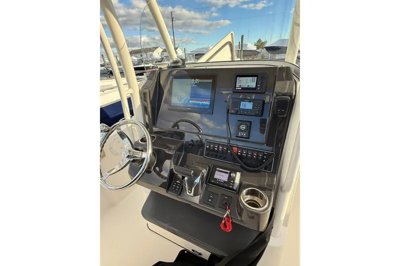 Slide: The Image of 2021 Pursuit C 238 Center Console boat dashboard with steering wheel and navigation controls. - 12