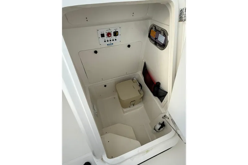 Slide: The Image of 2021 Pursuit C 238 Center Console boat with beige seating, docked near a bridge. - 16