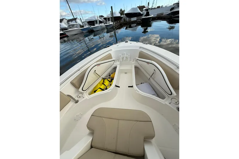 Slide: The Image of 2021 Pursuit C 238 Center Console boat with beige seating in a marina. - 18