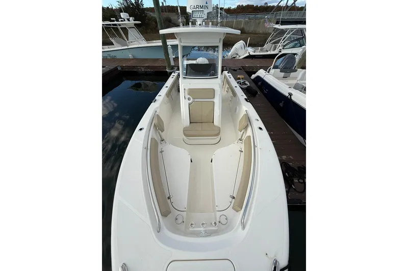 Slide: The Image of 2021 Pursuit C 238 Center Console boat with open storage compartments at marina. - 21