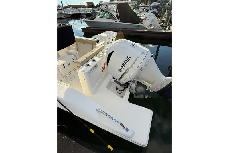 Slide: The Image of 2021 Pursuit C 238 Center Console boat docked in a marina under a cloudy sky. - 5