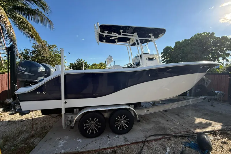 The Image of 2014 Sea Fox 256 Commander boat on trailer, parked outdoors under clear blue sky. - 1