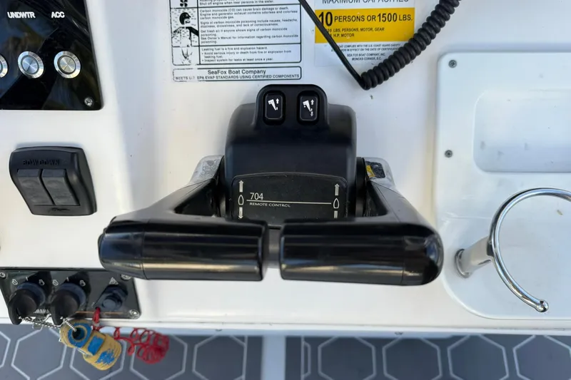 Slide: The Image of Control panel of a 2014 Sea Fox 256 Commander boat with throttle and switches. - 26