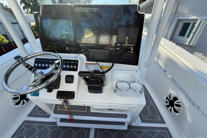 Slide: The Image of 2014 Sea Fox 256 Commander boat console with steering wheel, navigation screens, and controls. - 27