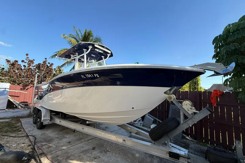 Slide: The Image of 2014 Sea Fox 256 Commander boat on trailer, parked outdoors under clear blue sky. - 3