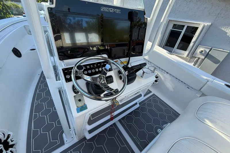 Slide: The Image of 2014 Sea Fox 256 Commander boat cockpit with steering wheel and navigation screens. - 30