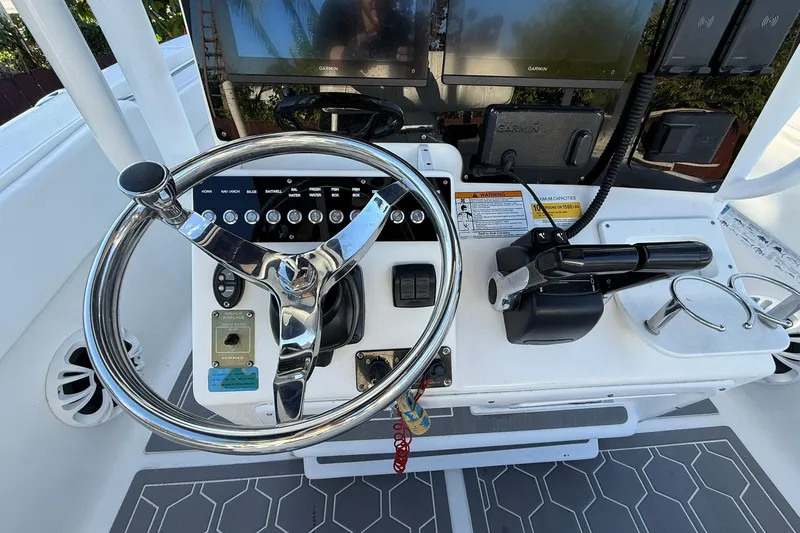 Slide: The Image of 2014 Sea Fox 256 Commander helm with steering wheel, controls, and Garmin displays. - 31