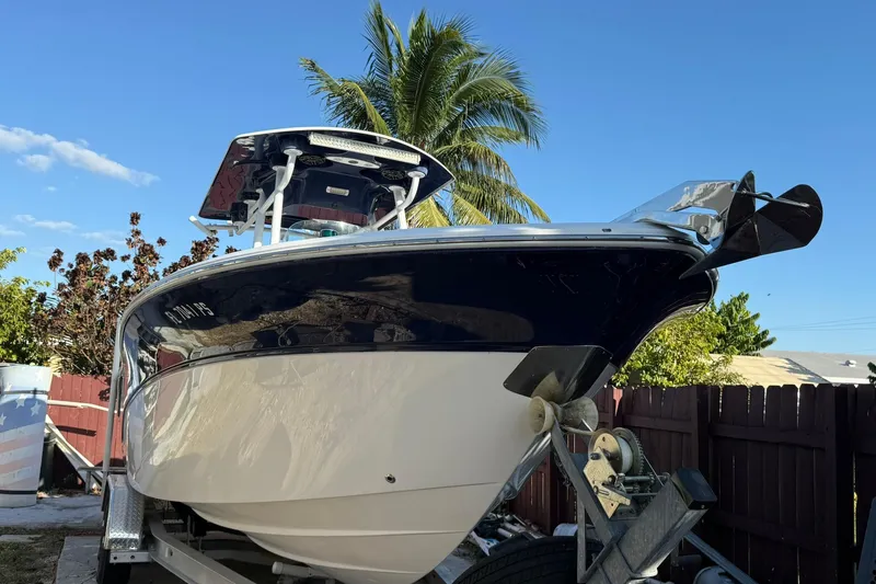 Slide: The Image of 2014 Sea Fox 256 Commander boat on trailer, palm tree background, clear blue sky. - 5