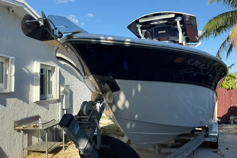 Slide: The Image of 2014 Sea Fox 256 Commander boat on trailer beside a house, under clear blue sky. - 6