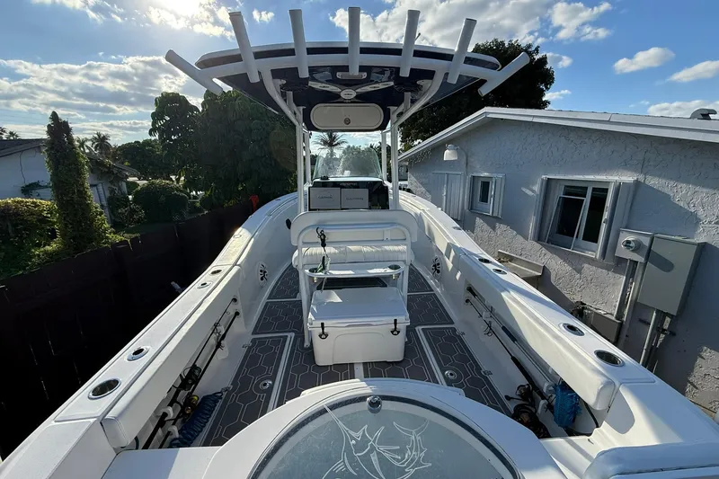 Slide: The Image of 2014 Sea Fox 256 Commander boat with spacious deck and modern design, docked near a house. - 7