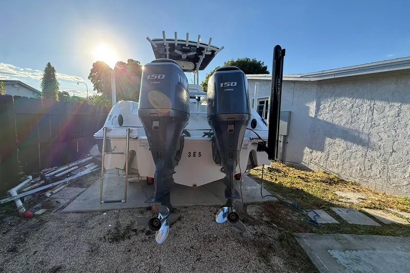 Slide: The Image of 2014 Sea Fox 256 Commander boat with dual Yamaha 150 engines in a sunny yard. - 76