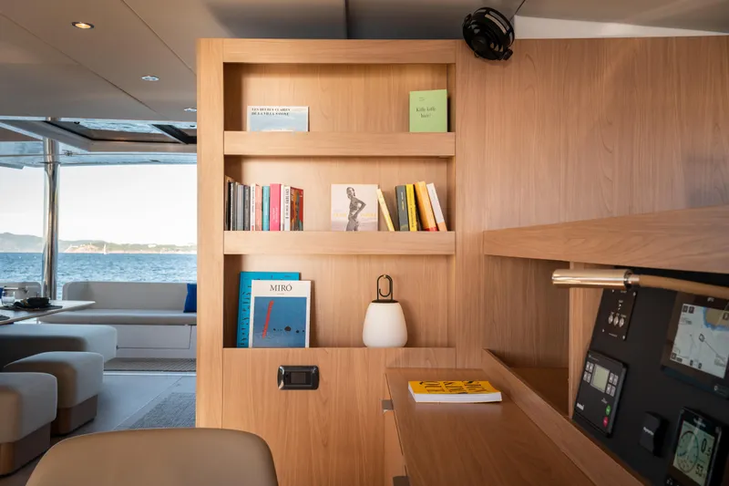 Slide: The Image of Luxurious Bali 5.8 yacht interior with wooden bookshelf, modern decor, and ocean view, 2026 model. - 10
