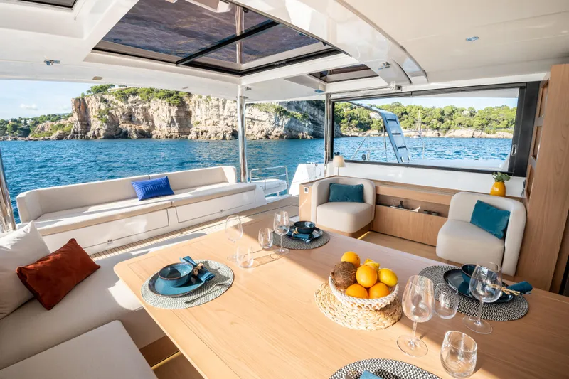 Slide: The Image of Luxurious Bali 5.8 yacht interior with elegant dining setup, overlooking scenic ocean view, 2026 model. - 4