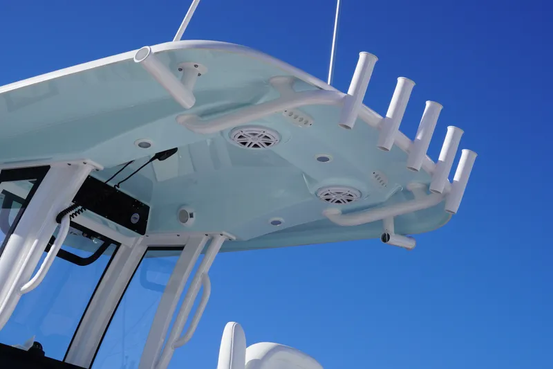 Slide: The Image of 2026 Sportsman Open 232 Center Console boat top view with rod holders against blue sky. - 8