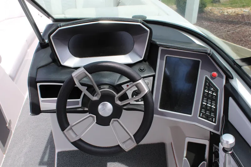 Slide: The Image of 2019 MasterCraft X26 boat dashboard with steering wheel and touchscreen controls. - 16