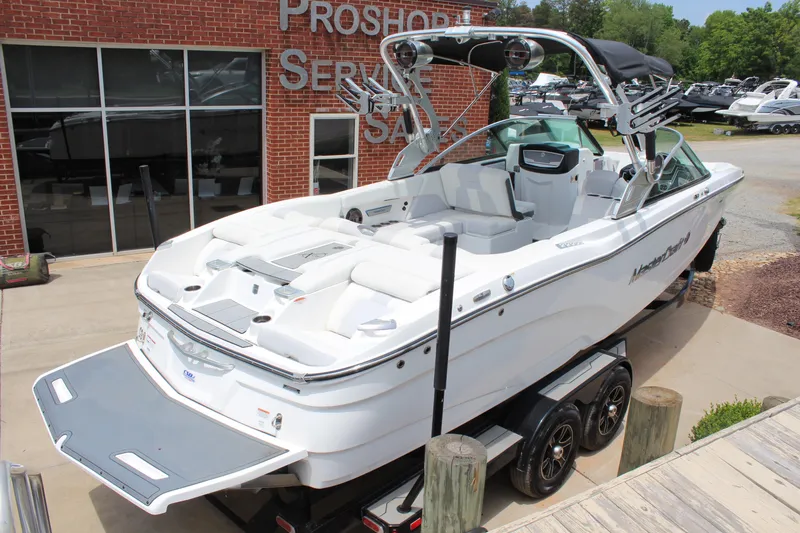 Slide: The Image of 2019 MasterCraft X26 boat on trailer outside dealership, showcasing sleek design and spacious interior. - 3