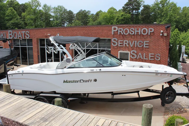 Slide: The Image of 2019 MasterCraft X26 boat on trailer outside a pro shop. - 4