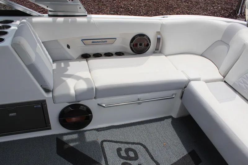 Slide: The Image of 2019 MasterCraft X26 boat interior with white seating and speaker system. - 9