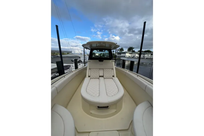 Slide: The Image of 2023 Chris-Craft Catalina 30 boat with luxurious seating, docked under a partly cloudy sky. - 10