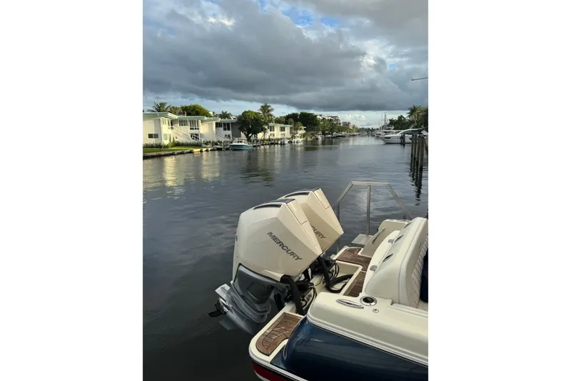 Slide: The Image of 2023 Chris-Craft Catalina 30 boat on a serene canal with cloudy skies. - 17