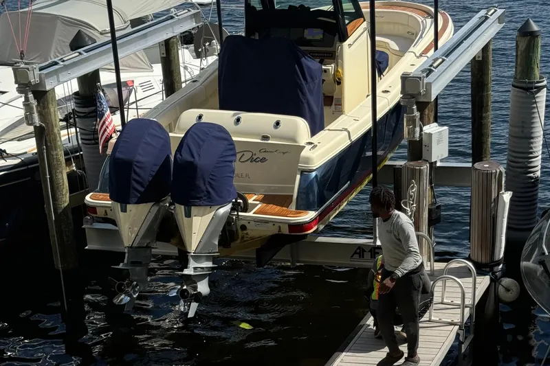 Slide: The Image of 2023 Chris-Craft Catalina 30 boat docked with dual engines, person on pier nearby. - 2
