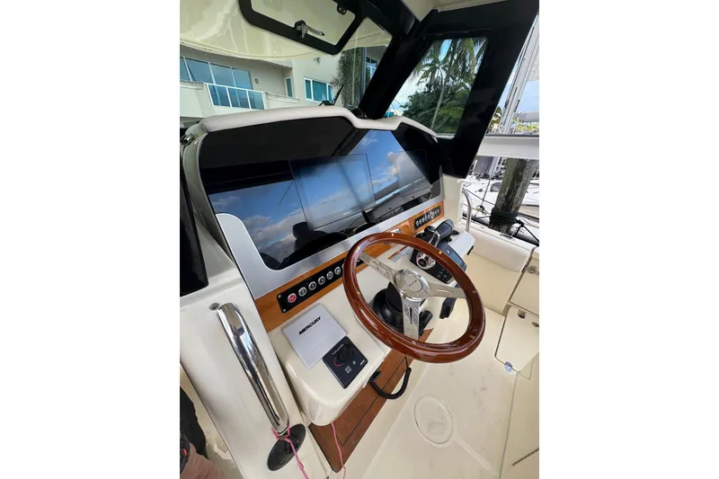 Slide: The Image of 2023 Chris-Craft Catalina 30 helm with wooden steering wheel and modern controls. - 7
