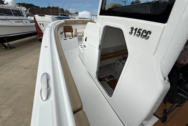 Slide: The Image of 2026 Everglades 315 Center Console boat with open cabin door, docked outdoors. - 16